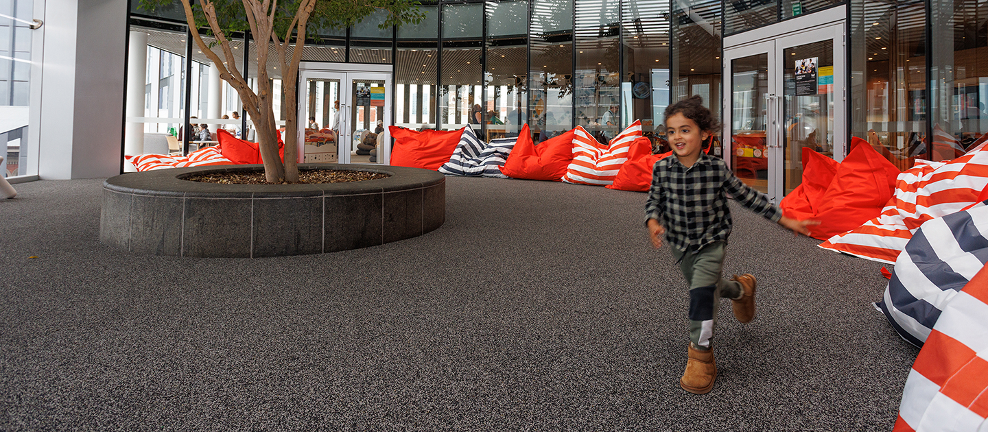 Child running through the Tree area of Level 4 of the Library.