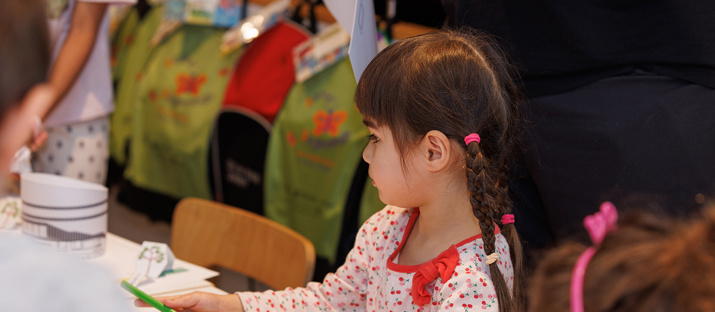 Young girl with plaits participating in a craft activity in the Library.