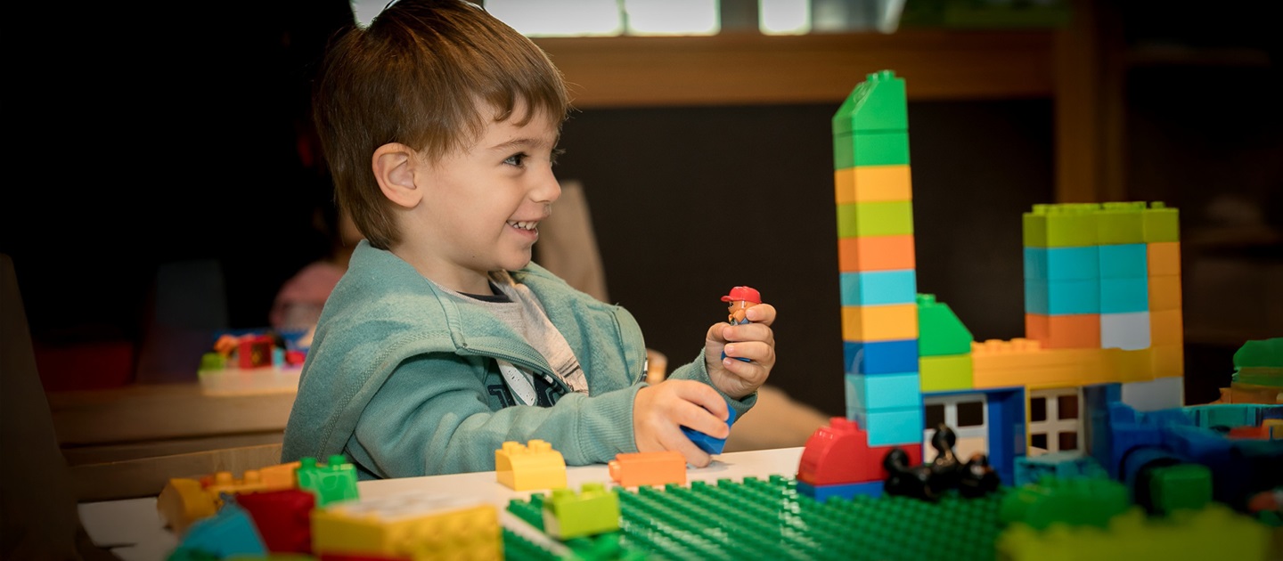 Child playing with DUPLO blocks in the Library.