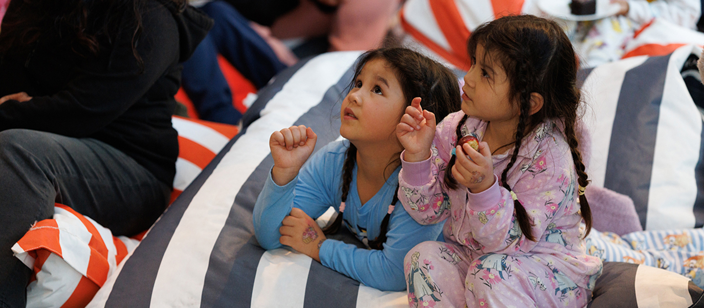 Girls in pyjamas listening to a story.