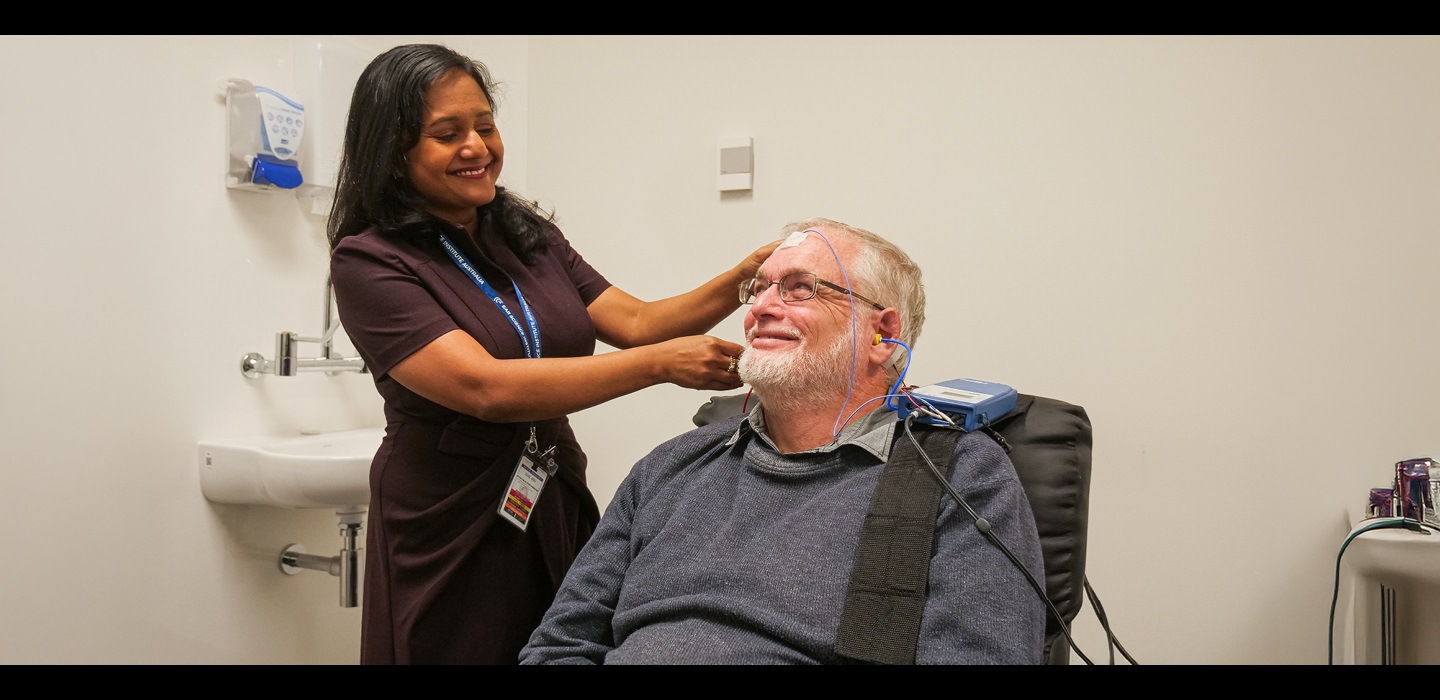Dr Dona Jayakody attaching wires to the head of a male patient.