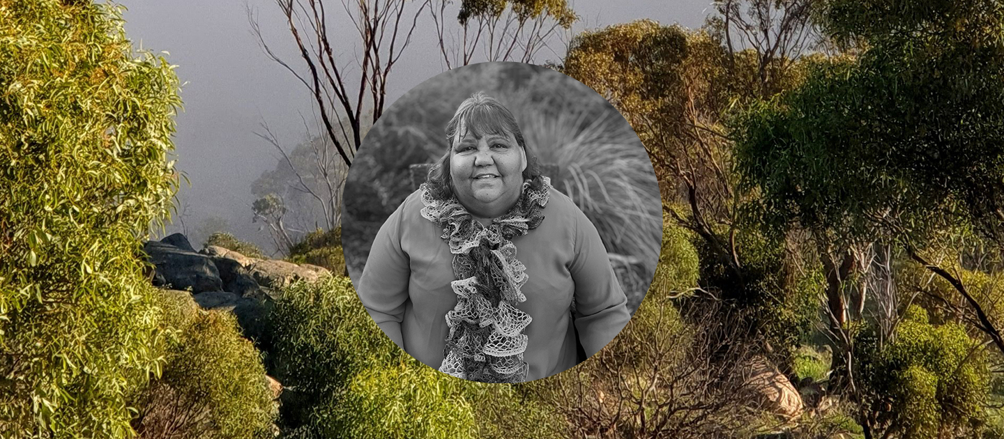 Black and white portrait photo of Dr Marion Kickett against a colour photo background of the countryside around York. 