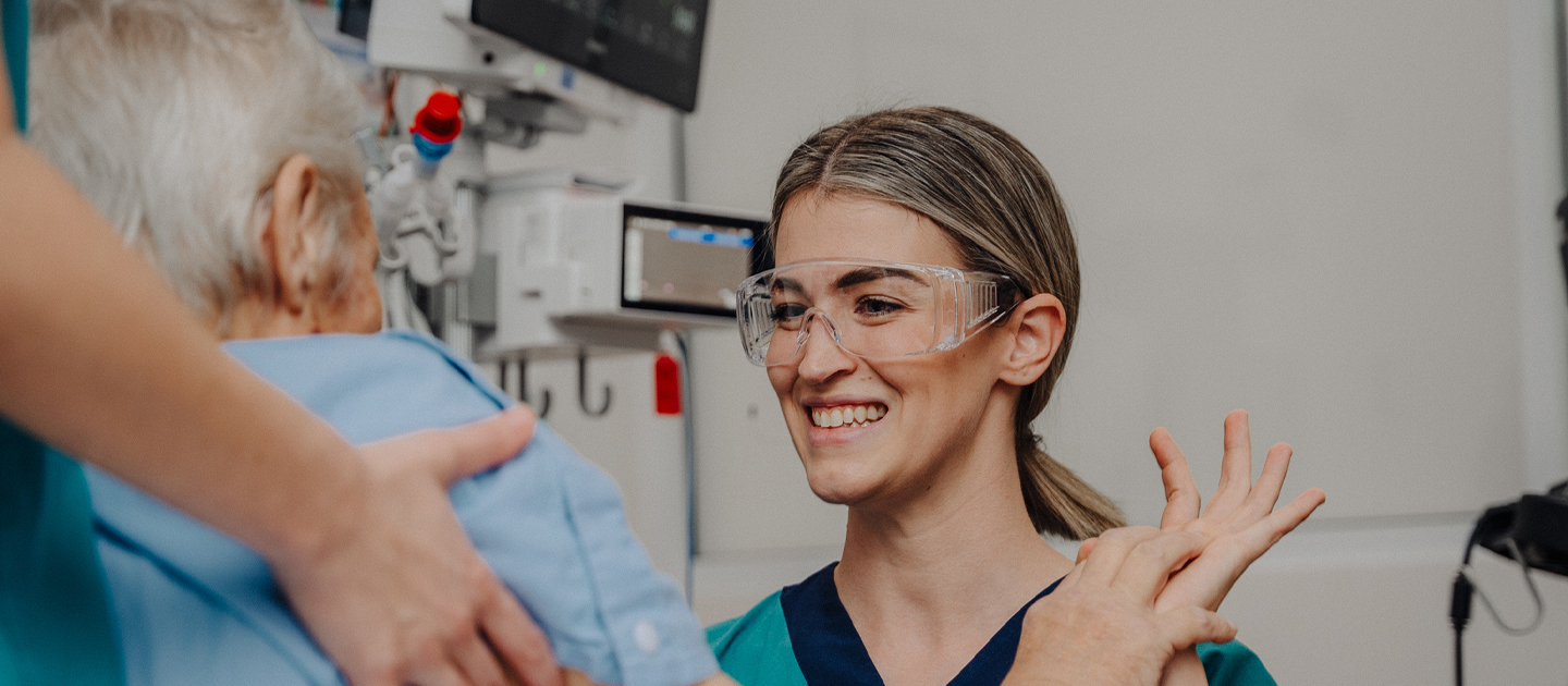 Female medical worker smiling and interacting with an elderly patient.