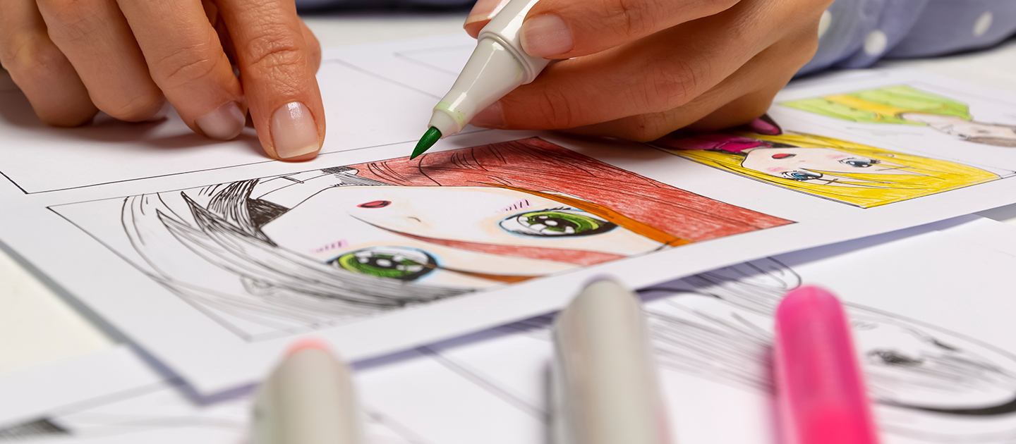 Close up shot of hands holding a marker and drawing Manga. 