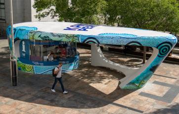 Information Kiosk worker giving two men perth tourist information.