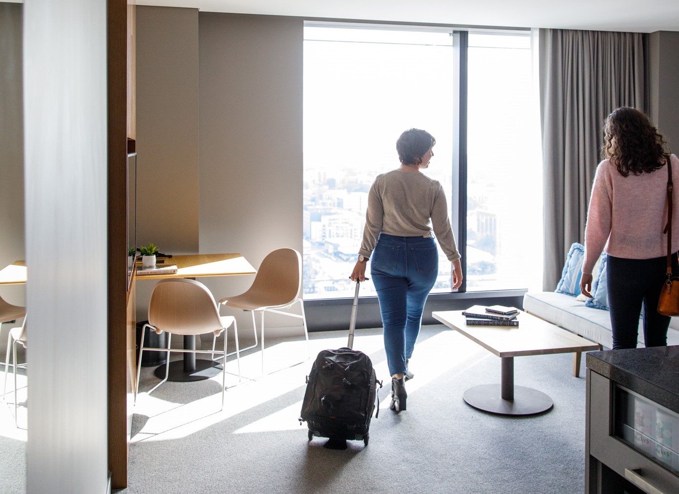 Two ladies with luggage arriving at hotel room