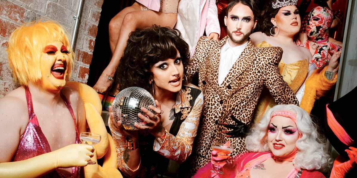 Fringe Freak Out performers stand in a group in a doorway. Someone in the centre holds a disco ball.