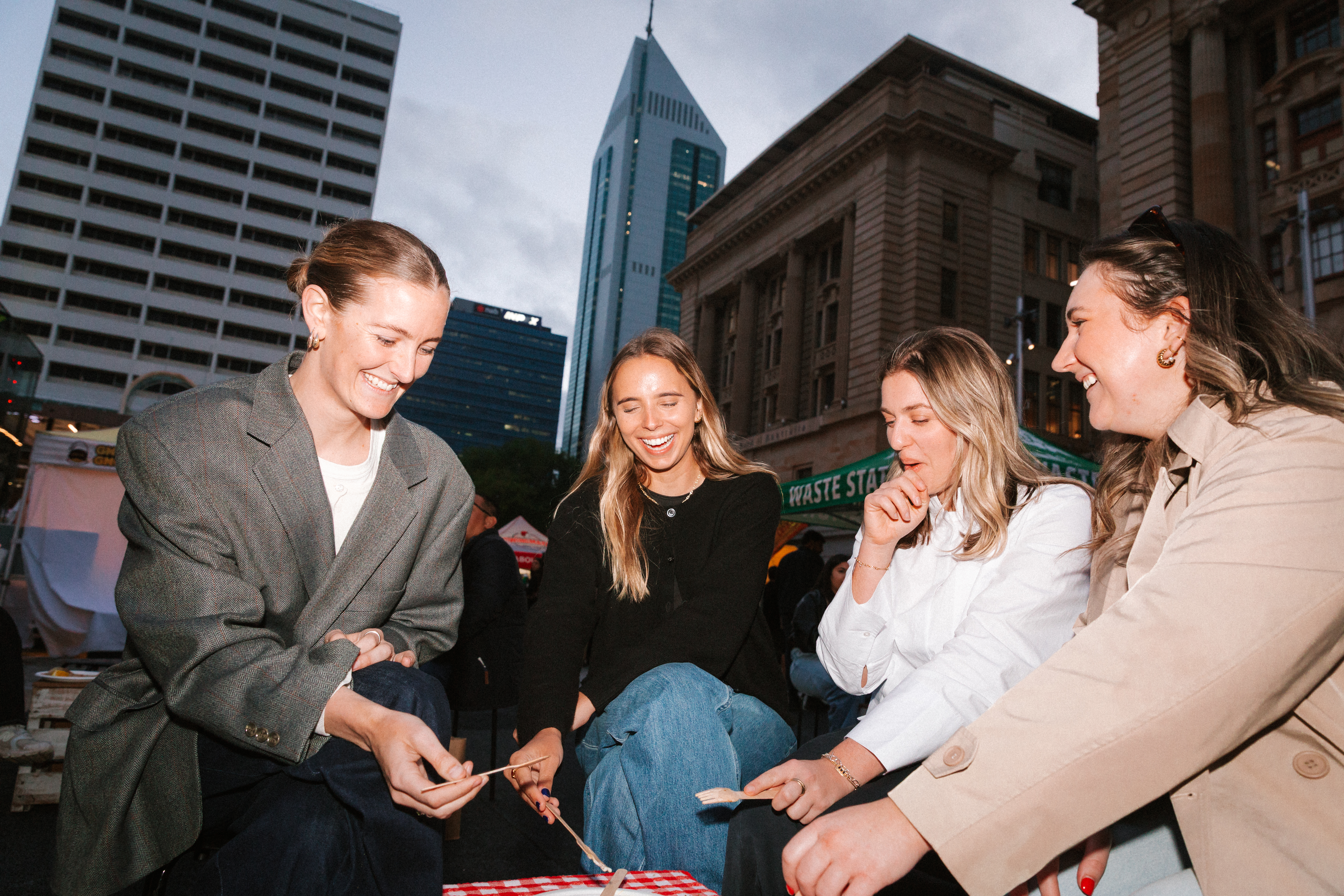 four women at twilight food market