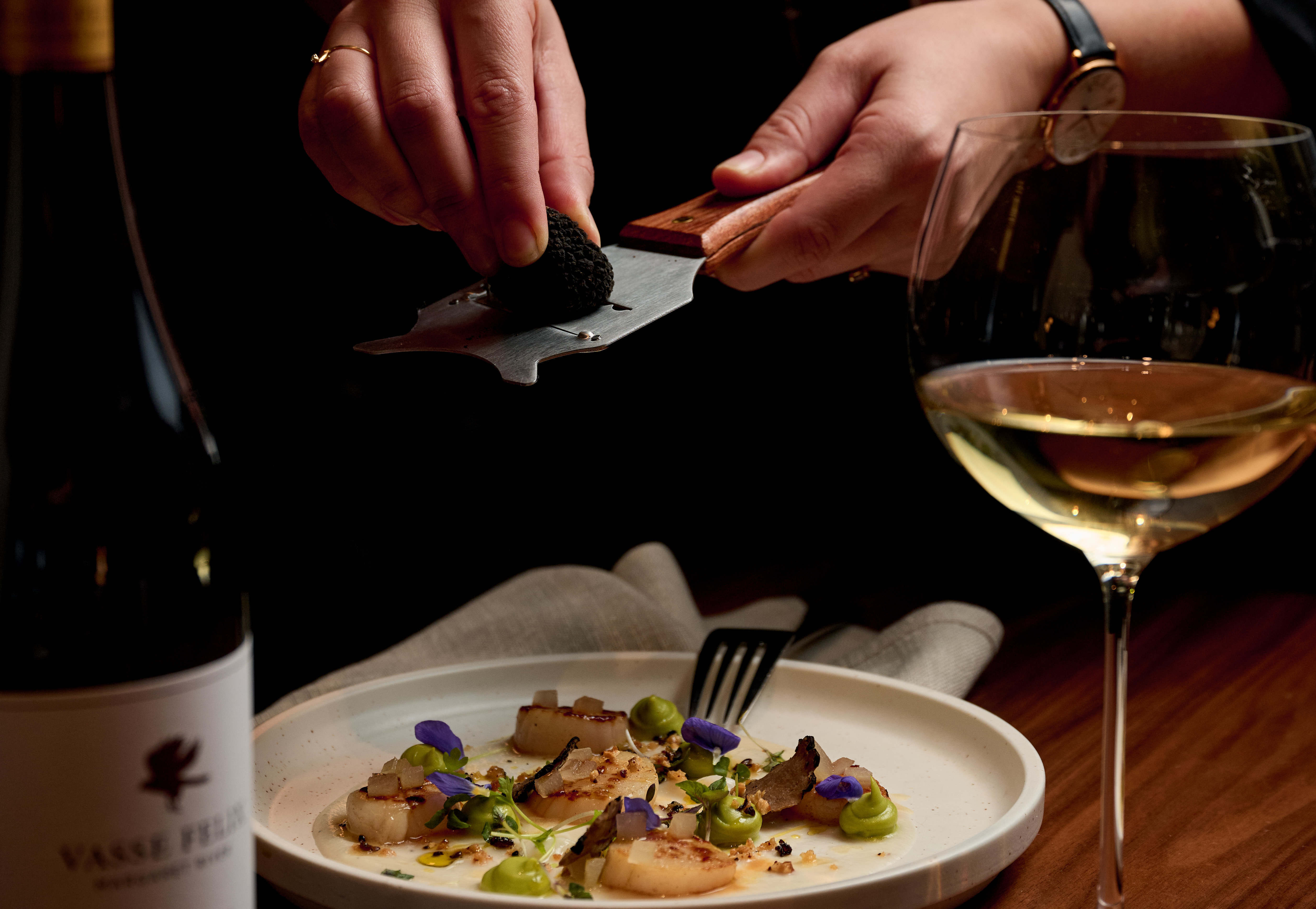 shaving truffle over plate of food
