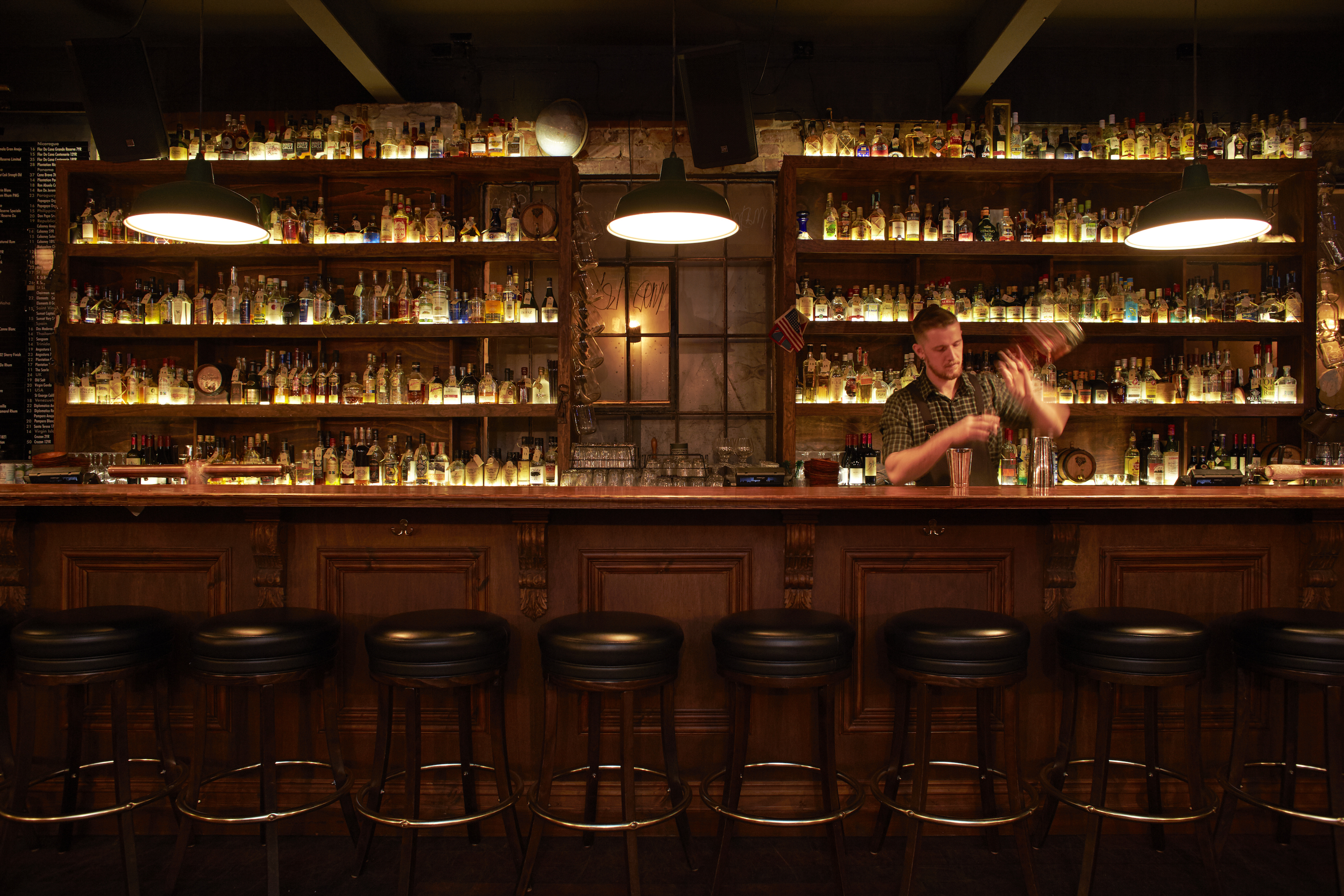 Bartender at wooden bar at Sneaky Tony's