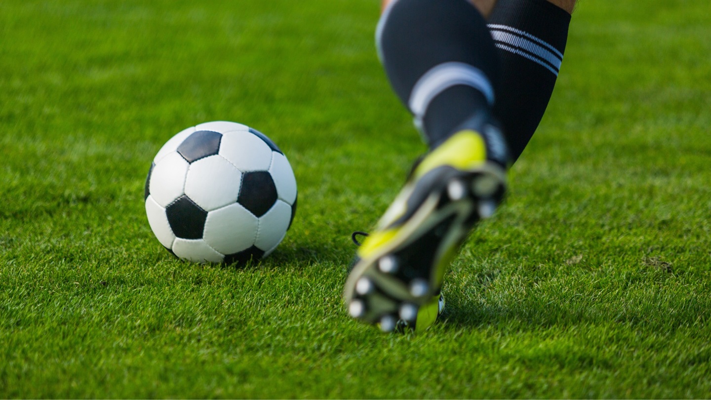 A soccer player poised to kick a soccer ball
